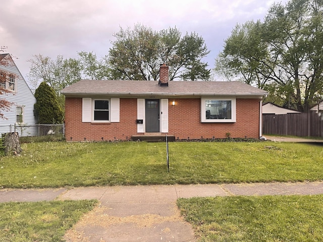 ranch-style house with brick siding, fence, and a chimney