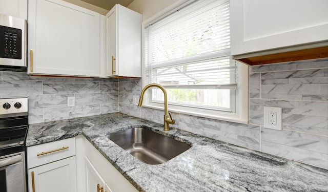 4589 Annhurst Rd, Columbus, OH 43228 - kitchen featuring a sink, backsplash, stainless steel electric range, white cabinetry, and light stone countertops