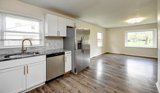 4589 Annhurst Rd, Columbus, OH 43228 - kitchen with stainless steel appliances, a sink, white cabinets, backsplash, and wood finished floors