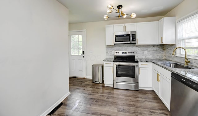 4589 Annhurst Rd, Columbus, OH 43228 - kitchen with stainless steel appliances, a sink, a chandelier, light stone counters, and backsplash