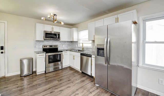 4589 Annhurst Rd, Columbus, OH 43228 - kitchen featuring stainless steel appliances, a sink, light stone counters, white cabinetry, and tasteful backsplash