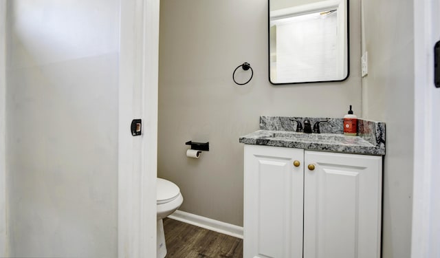4589 Annhurst Rd, Columbus, OH 43228 - half bath with baseboards, wood finished floors, vanity, and toilet