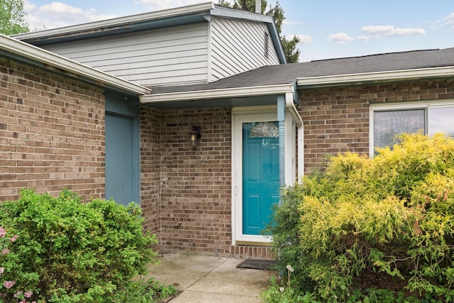 entrance to property featuring brick siding
