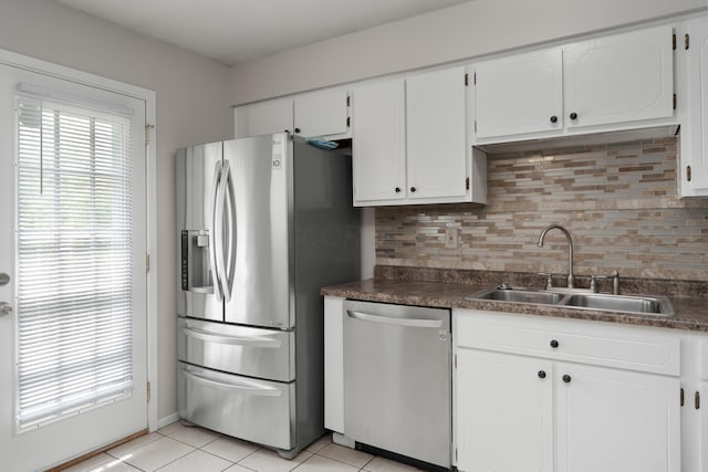 kitchen with stainless steel appliances, a sink, dark countertops, and tasteful backsplash