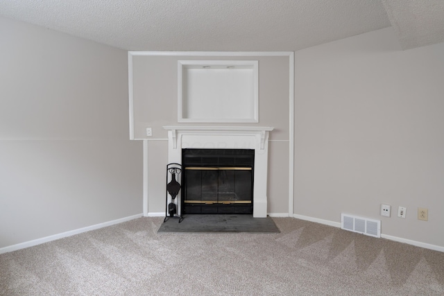 detailed view of carpet floors, a glass covered fireplace, a textured ceiling, and baseboards
