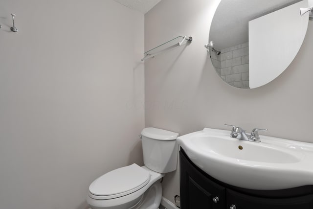 bathroom with toilet, vanity, and a textured ceiling