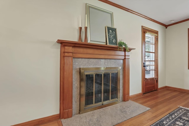 interior details with crown molding, baseboards, a high end fireplace, and wood finished floors