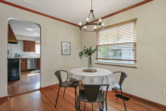 dining space featuring baseboards, hardwood / wood-style flooring, and an inviting chandelier