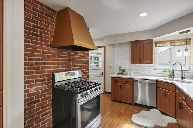 kitchen featuring backsplash, island exhaust hood, a sink, light countertops, and stainless steel appliances
