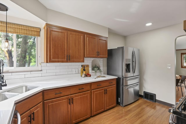 kitchen featuring visible vents, brown cabinetry, light wood-style floors, light countertops, and stainless steel appliances