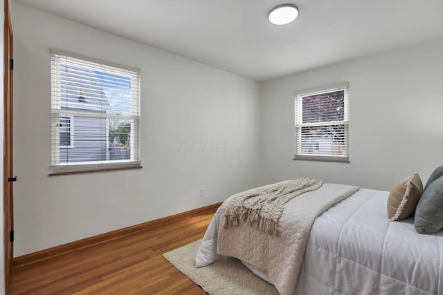 bedroom featuring baseboards and wood finished floors