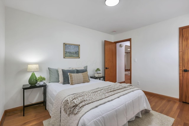 bedroom featuring baseboards and wood finished floors