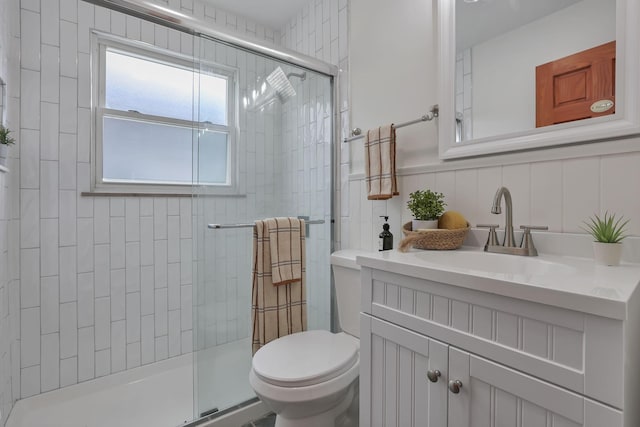 full bath featuring vanity, a tile shower, and toilet