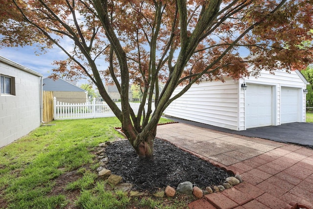 view of yard with fence, an outbuilding, and a garage