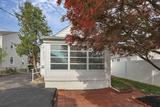 view of home's exterior with a patio area and fence