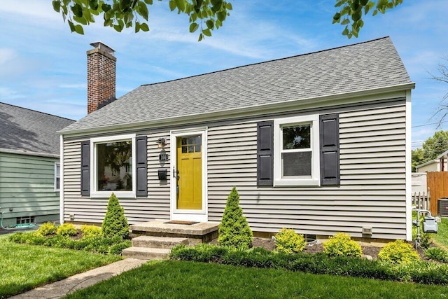 bungalow featuring roof with shingles, a front lawn, and a chimney