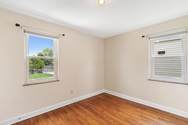 unfurnished room with baseboards and wood finished floors