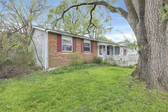 5143 Rutledge Dr N, Columbus, OH 43232 - view of front facade featuring fence, a front lawn, and brick siding