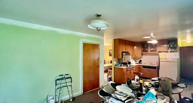 1455 Fairview Ave, Bucyrus, OH 44820 - kitchen featuring freestanding refrigerator, dark carpet, brown cabinetry, and oven