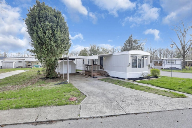 2445 Columbus Lancaster Rd NW, Lancaster, OH 43130 - manufactured / mobile home featuring an outdoor structure, a carport, driveway, and a front lawn