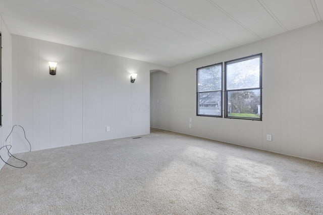 empty room with arched walkways and carpet