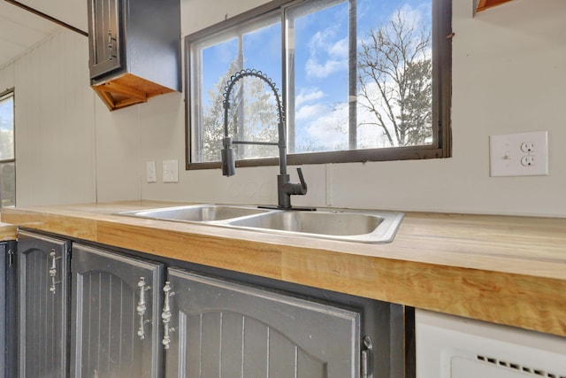 kitchen with butcher block countertops and a sink