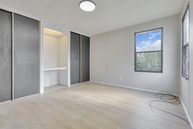 unfurnished bedroom featuring multiple closets and wood finished floors