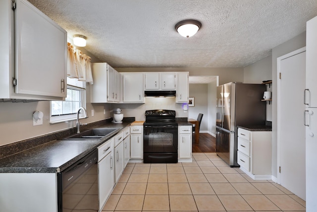 kitchen featuring black appliances, a sink, under cabinet range hood, dark countertops, and white cabinetry