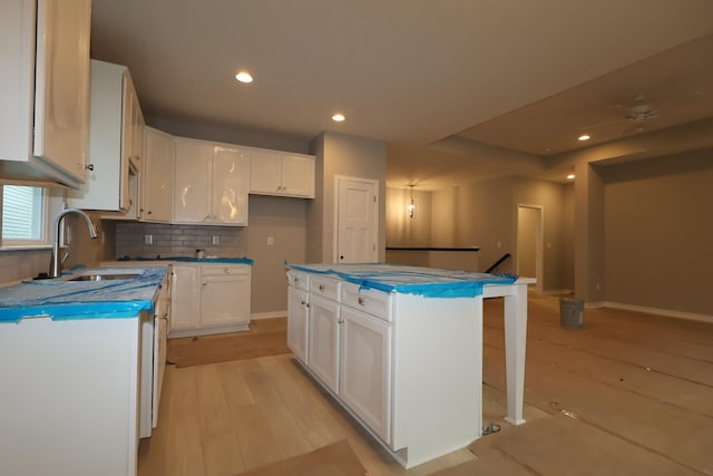378 Canterbury Rd, Commercial Point, OH 43116 - kitchen featuring white cabinetry, light wood-style flooring, decorative backsplash, a center island, and recessed lighting