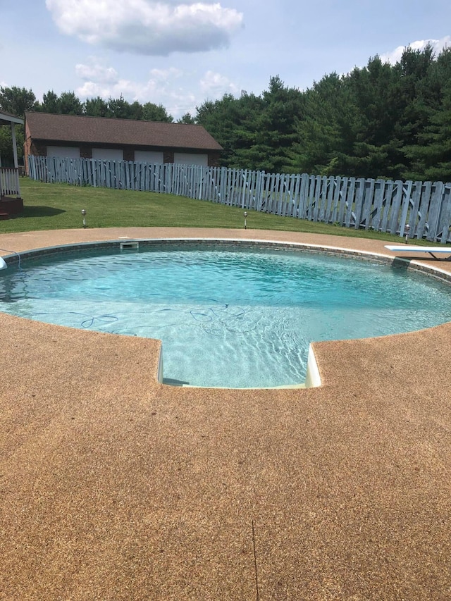 view of pool featuring fence, a fenced in pool, a diving board, and a lawn