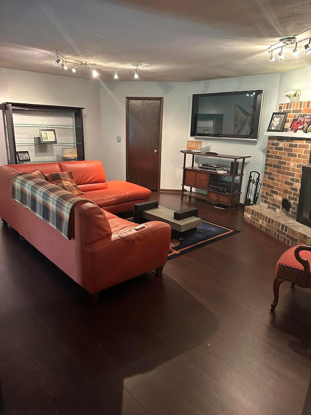 living area with track lighting and wood finished floors