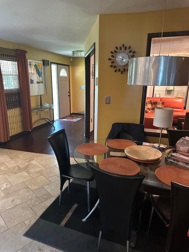 dining space featuring a textured ceiling and stone tile flooring