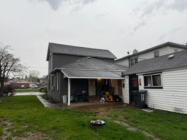 rear view of house with a lawn and a patio