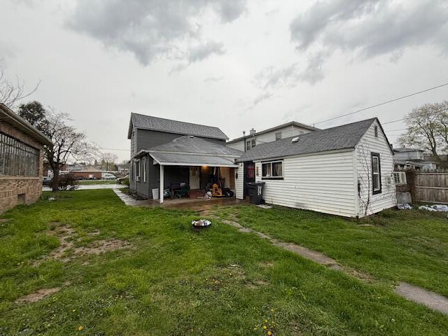 rear view of house with a yard, a patio, and fence