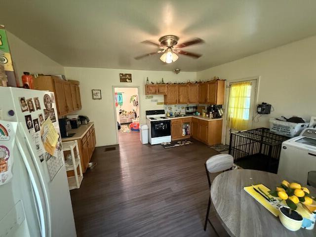 kitchen featuring brown cabinetry, white appliances, ceiling fan, dark wood-style floors, and light countertops