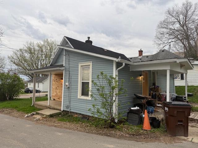 view of home's exterior with covered porch and a chimney