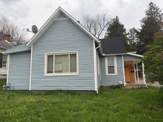 rear view of house with a lawn and a porch