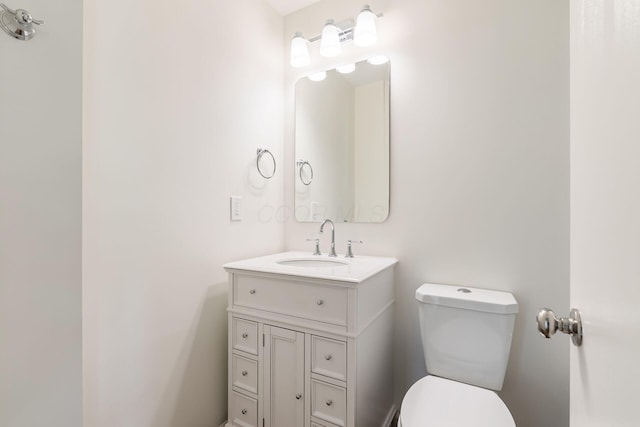 half bathroom featuring vanity and toilet