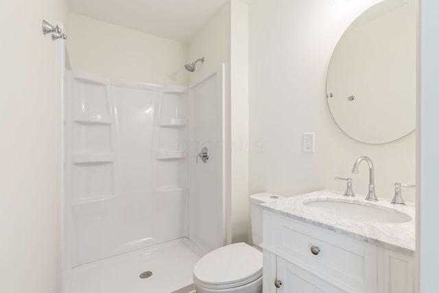 full bathroom featuring vanity, walk in shower, and toilet