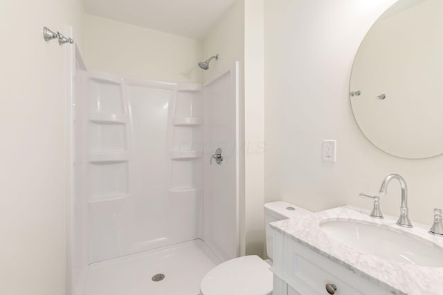 full bathroom with vanity, walk in shower, and toilet