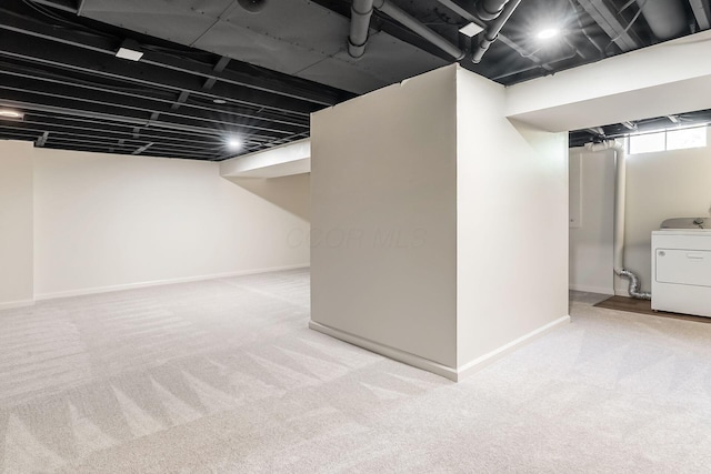 below grade area with baseboards, carpet flooring, and washer / dryer
