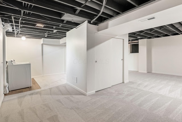 finished basement with baseboards, washer and clothes dryer, carpet flooring, and visible vents
