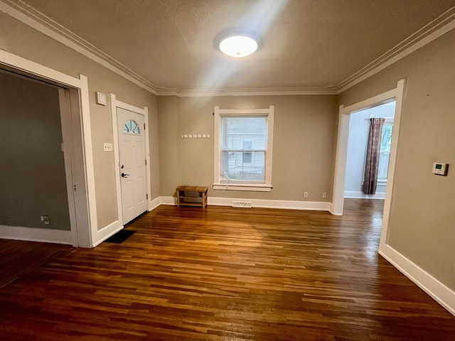 interior space featuring baseboards, visible vents, dark wood-style floors, and ornamental molding