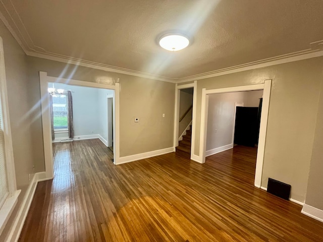 empty room with baseboards, ornamental molding, stairs, and hardwood / wood-style floors