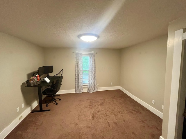 unfurnished office featuring dark carpet, a textured ceiling, and baseboards