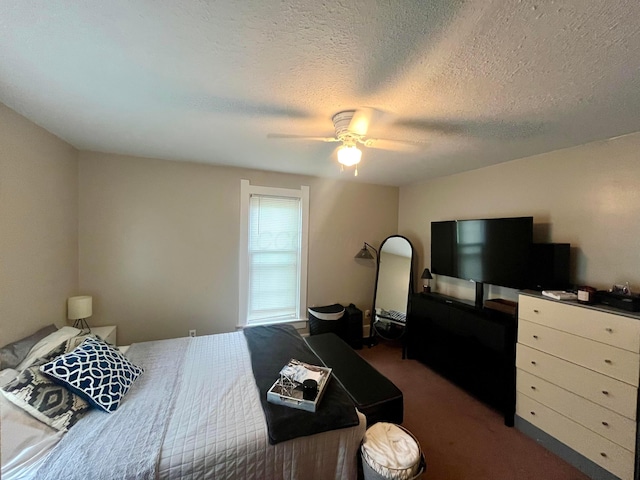 bedroom with ceiling fan, carpet flooring, and a textured ceiling