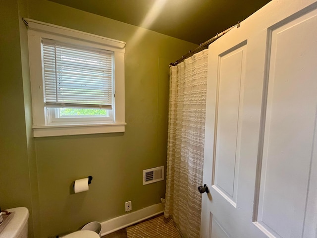 full bathroom featuring visible vents, baseboards, toilet, and a shower with curtain