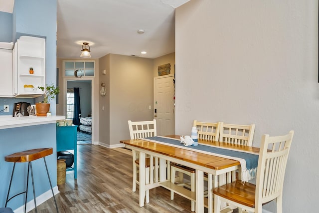 dining space with baseboards and wood finished floors