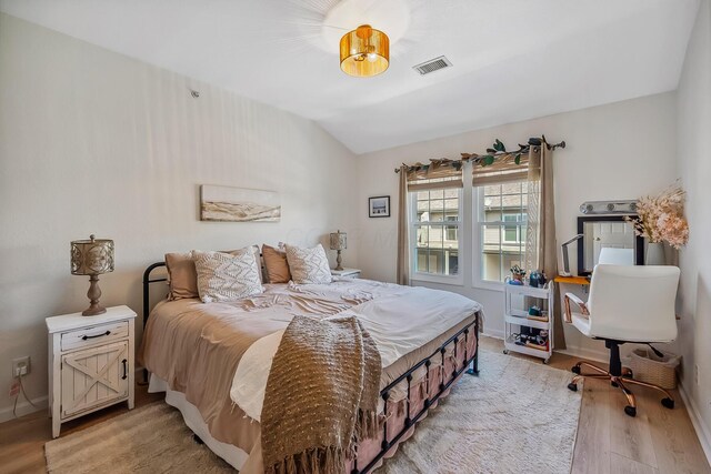 bedroom featuring visible vents, light wood finished floors, and baseboards