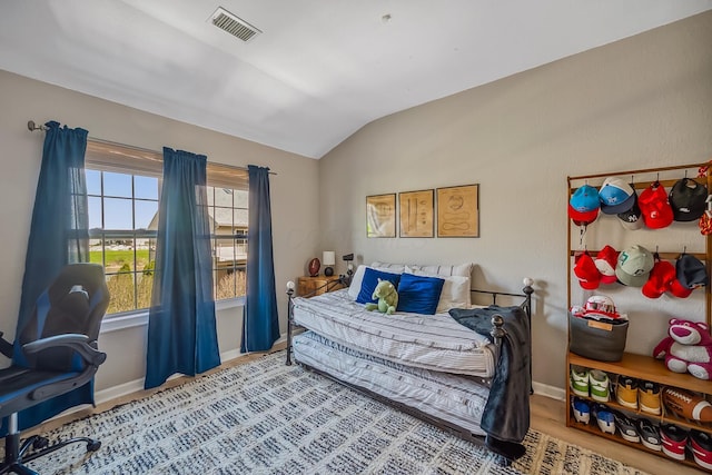 bedroom featuring baseboards, vaulted ceiling, and visible vents